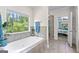 A luxurious bathtub with serene wooded views enhances this bathroom at 105 Turnberry Trce, Sharpsburg, GA 30277