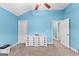 Bright bedroom with blue walls, white trim, ceiling fan, and a decorative ship on the dresser at 105 Turnberry Trce, Sharpsburg, GA 30277