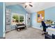 Bright bedroom with vaulted ceiling has a window with a view, a sofa and a desk for studying at 105 Turnberry Trce, Sharpsburg, GA 30277