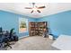 Bright bedroom featuring a ceiling fan, desk, bookshelf, and large window overlooking backyard at 105 Turnberry Trce, Sharpsburg, GA 30277