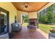 Inviting covered patio with stone fireplace, wood ceiling, outdoor seating, and a view of the backyard at 105 Turnberry Trce, Sharpsburg, GA 30277