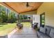 Relaxing covered patio with outdoor seating, wood ceiling, and view of the spacious backyard at 105 Turnberry Trce, Sharpsburg, GA 30277