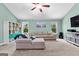 A well-lit upstairs living room with a sectional sofa, bookcase, and television at 105 Turnberry Trce, Sharpsburg, GA 30277