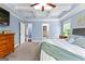 Main bedroom featuring a tray ceiling, ceiling fan, carpet and access to the bathroom at 105 Turnberry Trce, Sharpsburg, GA 30277
