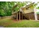 View of the house and backyard featuring a deck, stairs, brick foundation, and fenced perimeter at 170 River Forest Dr, Fayetteville, GA 30214