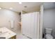 Bright bathroom with a double sink vanity, white tile floors, and a shower with a white shower curtain at 170 River Forest Dr, Fayetteville, GA 30214