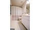 Well-lit bathroom features a white toilet, shower with a polka dot curtain, and white tiled floor at 170 River Forest Dr, Fayetteville, GA 30214
