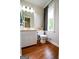 Bathroom featuring vanity with large mirror, toilet, window and wood flooring at 170 River Forest Dr, Fayetteville, GA 30214