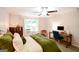 Well-lit bedroom with a desk and chair next to a window dressed with white curtains at 170 River Forest Dr, Fayetteville, GA 30214