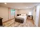 Well-lit bedroom features a white bed, wood floors, and a large window overlooking a beautiful wooded backyard at 170 River Forest Dr, Fayetteville, GA 30214