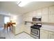Open-concept kitchen with white cabinets, stainless steel appliances, and adjacent dining area perfect for Gathering meals at 170 River Forest Dr, Fayetteville, GA 30214