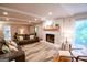 Inviting living room with stone fireplace, wood mantle, hardwood floors, with leather sofas, and plenty of natural light at 170 River Forest Dr, Fayetteville, GA 30214