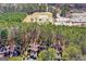 Aerial view of townhomes backing up to a wooded area near a park and school with playground and sports fields at 53 Cobblestone Crk, Peachtree City, GA 30269