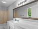 Bright bathroom boasts a large framed mirror, single sink vanity and shower/tub combo at 53 Cobblestone Crk, Peachtree City, GA 30269