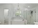Bright bathroom featuring soaking tub, glass shower, and elegant chandelier, offering a spa-like experience at 20 Allie Dr, Mcdonough, GA 30252
