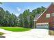Home exterior with a large, paved driveway, brick facade, manicured lawn, and spacious two car garage at 20 Allie Dr, Mcdonough, GA 30252