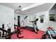 Home gym featuring modern exercise equipment, weights, and a vibrant red floor at 20 Allie Dr, Mcdonough, GA 30252