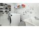 Well-organized laundry room with modern washer, dryer, shelving, and utility sink at 20 Allie Dr, Mcdonough, GA 30252