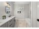 Bright bathroom with a long countertop, double sinks, and modern white tiled shower and tub at 2018 Presley, Atlanta, GA 30317