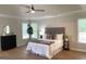 Bright bedroom featuring a tray ceiling, ceiling fan, wood floors, and large windows with natural light at 219 Maple Creek Chase, Woodstock, GA 30188