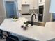 Bright kitchen featuring a center island with bar seating, stainless steel sink, and white cabinetry at 219 Maple Creek Chase, Woodstock, GA 30188