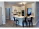 Bright kitchen features white cabinets, stainless appliances, a center island with bar seating and wood flooring at 219 Maple Creek Chase, Woodstock, GA 30188
