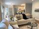 Inviting living room showcasing wood floors and opening up to a bright kitchen with bar stool seating at 219 Maple Creek Chase, Woodstock, GA 30188