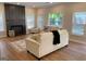 Bright living room featuring wood floors, a fireplace, and comfortable seating at 219 Maple Creek Chase, Woodstock, GA 30188