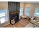 Bright living room with a fireplace, wood floors, and comfortable seating near large windows at 219 Maple Creek Chase, Woodstock, GA 30188
