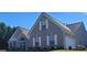 Lovely brick home with a manicured lawn, trimmed shrubs, and neutral shutters under a blue sky at 3008 Brighton Ct, Conyers, GA 30094