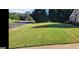 Well-manicured front yard featuring lush green grass, mature trees, and a street view at 3008 Brighton Ct, Conyers, GA 30094