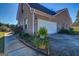 Side view of home featuring a two-car garage, brick exterior, and landscaped pathway at 3008 Brighton Ct, Conyers, GA 30094