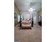 Large main bedroom with a four-poster bed, light carpet, ceiling fan, and sitting bench in front of the bed at 3008 Brighton Ct, Conyers, GA 30094