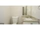 Clean bathroom with a toilet, a modern vanity with a granite countertop, and a large mirror at 3587 Oakvale Ave, Decatur, GA 30034