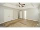 Large main bedroom with tray ceilings, ceiling fan, carpeted floors, and access to the bathroom at 3587 Oakvale Ave, Decatur, GA 30034