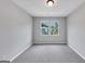 A room with gray walls and carpet, illuminated by natural light through windows offering neighborhood views at 107 Cedar Brook Dr, Canton, GA 30115