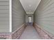 Covered entryway features stylish siding, a brick foundation, and an elegant glass-paneled front door, creating a welcoming entrance at 107 Cedar Brook Dr, Canton, GA 30115