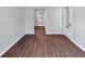 A hallway featuring modern hardwood floors, neutral walls, and access to the home's entrance at 107 Cedar Brook Dr, Canton, GA 30115