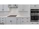 Well-equipped kitchen with stainless steel double ovens, smooth cooktop, and subway tile backsplash at 107 Cedar Brook Dr, Canton, GA 30115