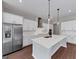 Open kitchen boasts stainless steel appliances, island with seating, white cabinets, and modern pendant lights at 107 Cedar Brook Dr, Canton, GA 30115