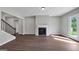 Well-lit living room features hardwood floors, a fireplace, and access to the backyard, with a staircase to the next level at 107 Cedar Brook Dr, Canton, GA 30115