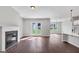 Bright living area boasts hardwood floors, a fireplace, and glass doors that open to a backyard, with a view to the kitchen at 107 Cedar Brook Dr, Canton, GA 30115