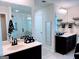 Bright bathroom featuring double vanity, a shower with glass door, and coordinated black and white decor at 2750 Brentwood Estates Ct, Cumming, GA 30041