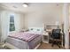 Bright bedroom with a bed, desk, and large window with patterned curtains at 2750 Brentwood Estates Ct, Cumming, GA 30041