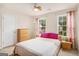 Bright bedroom featuring two windows with natural light, curtains, and a comfortable bed at 2750 Brentwood Estates Ct, Cumming, GA 30041