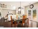 Bright dining room with modern light fixture and glass table overlooking the living room at 2750 Brentwood Estates Ct, Cumming, GA 30041
