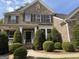 Lovely home featuring a symmetrical design, manicured bushes, and walkway to the front door at 2750 Brentwood Estates Ct, Cumming, GA 30041