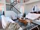 Bright living room with plush seating, wood floors, staircase, and stylish decor create inviting ambiance at 2750 Brentwood Estates Ct, Cumming, GA 30041