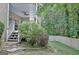 Backyard featuring a covered patio with ceiling fan, stone steps, and a privacy fence surrounded by trees at 102 Passage Point, Peachtree City, GA 30269