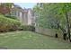 Manicured backyard featuring green lawn, trees, privacy fence, and patio heater at 102 Passage Point, Peachtree City, GA 30269